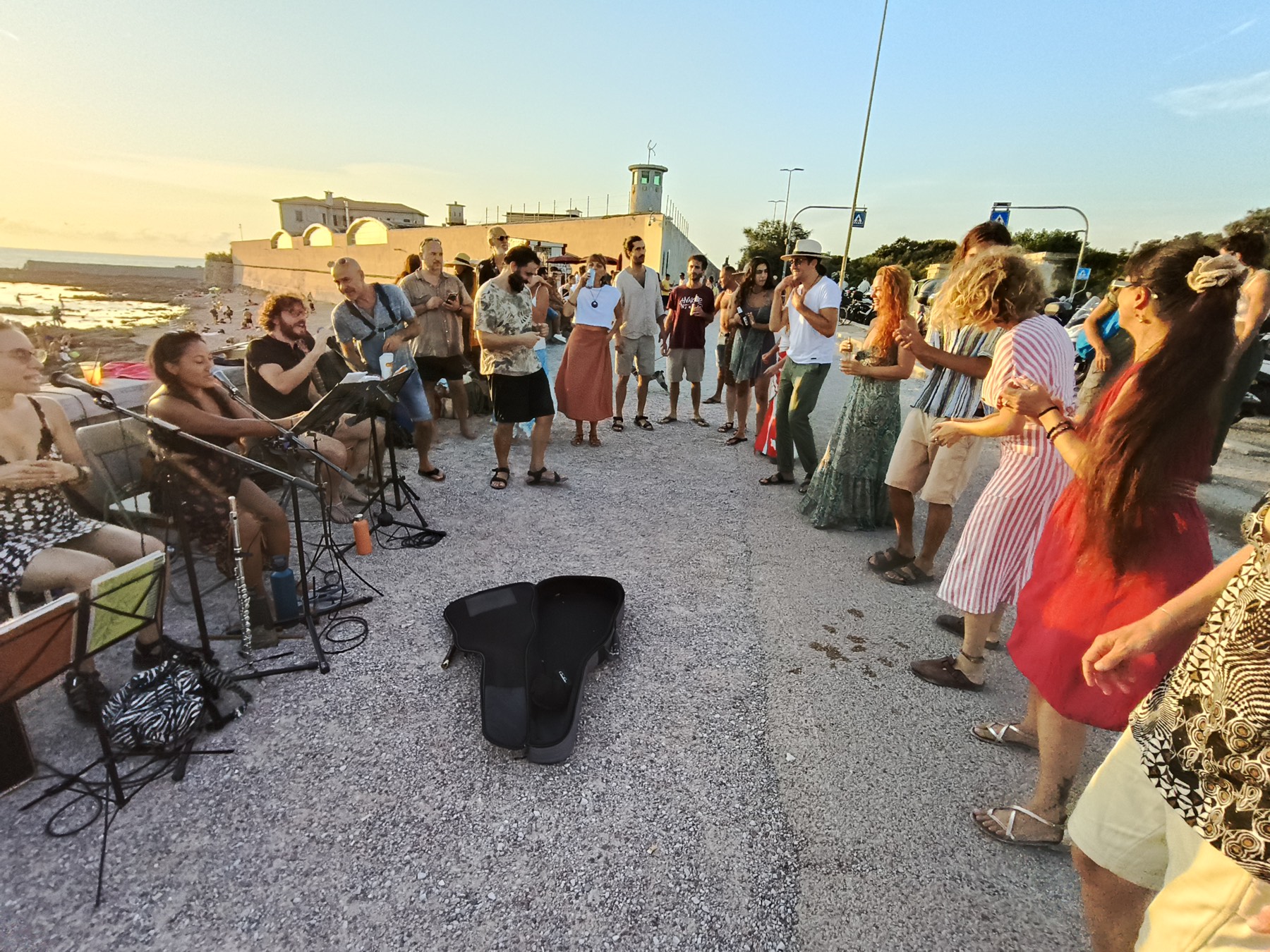 Peña del Colectivo sul lungomare all'ora d'oro: i musicisti seduti a sinistra, le persone che ballano a destra
