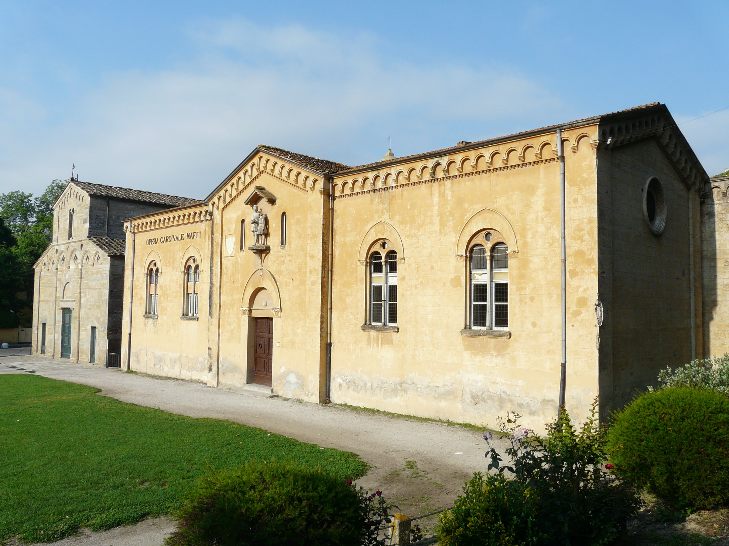 La Pieve romanica di Santa Maria e l'edificio dell'Opera Cardinale Maffi a Vicopisano, visti dal prato davanti